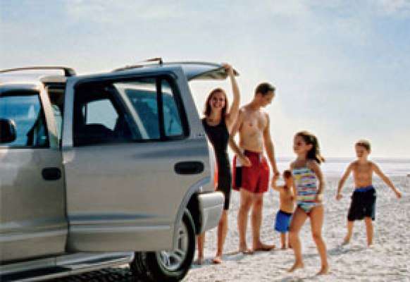 Famille heureuse arrive à la plage